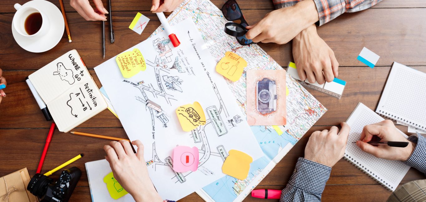 Picture of businessmen's hands on wooden table with documents, coffee and drafts